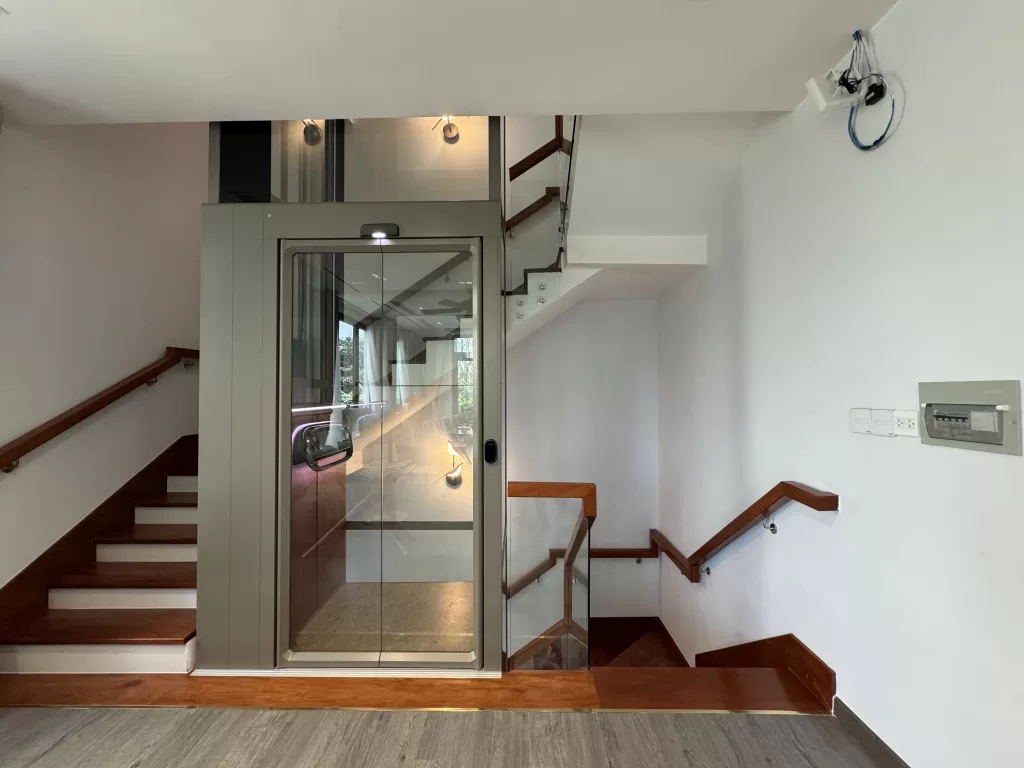 Kalea X50 Limited di rumah 3 lantai Vietnam dengan desain kaca dan posisi lift di tengah area tangga