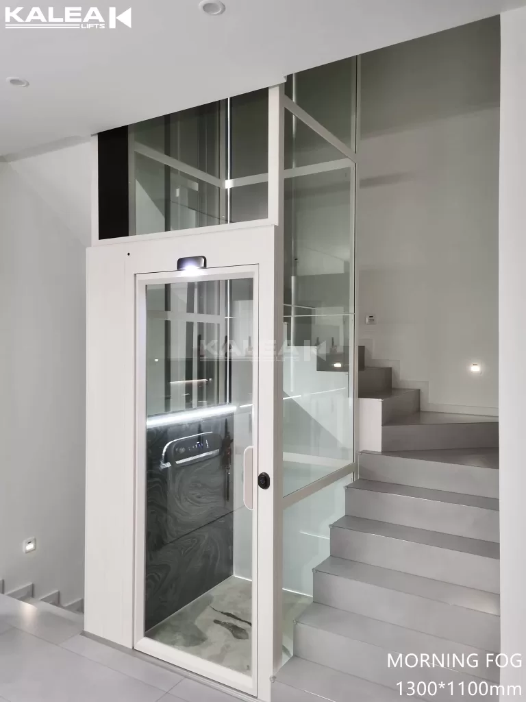 Lift rumah mewah Kalea X50 white powder coat di tengah tangga dengan tampilan minimalis